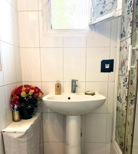 a bathroom with a sink and a window and flowers at paris kiffe in Villejuif