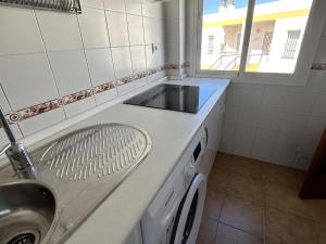 a kitchen with a sink and a washing machine at Los Pescadores Playa Sol in Novo Sancti Petri +32 photos
