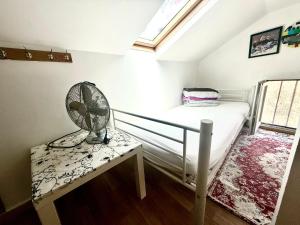 a bedroom with a bed with a fan on a table at paris kiffe in Villejuif