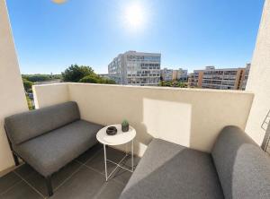 a balcony with a couch and a table on a building at ideal in Carnon-Plage