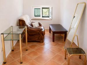 a living room with a leather chair and a table at Studio Apartman Blue Sky in Senj +12 photos