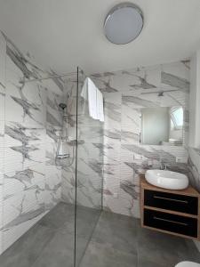 a bathroom with a sink and a glass shower at Domki Ostoja - nad Bałtykiem - cisza i piękno natury in Zastań