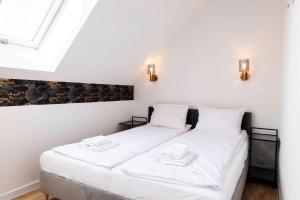 two beds in a room with white walls and a window at Domki Ostoja - nad Bałtykiem - cisza i piękno natury in Zastań