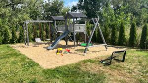 a playground with a slide in the sand at Domki Ostoja - nad Bałtykiem - cisza i piękno natury in Zastań