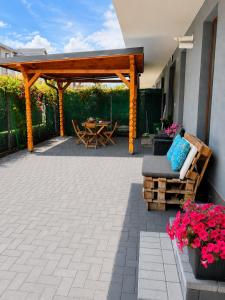 a patio with a wooden pergola and a table and chairs at Apartament 2 camere Narcis in Braşov