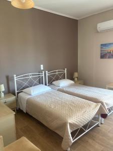 a bedroom with two beds and a lamp at Hotel Διεθνές in Zacharo