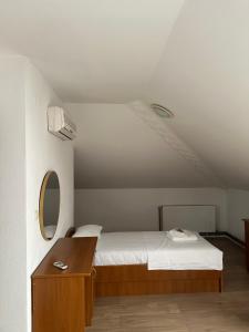 a bedroom with a bed and a dresser with a mirror at Restoran Orahovica Konjic - sobe in Konjic