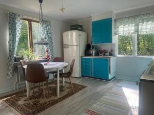 a kitchen with a table and a white refrigerator at Retro hus in Kosta +5 photos
