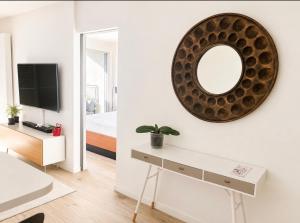 a white living room with a mirror and a table at ideal in Carnon-Plage
