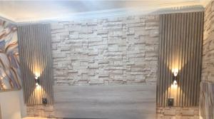 a room with a stone wall with two lights on it at MRH Self Check- In Express Homestay in Modimolle
