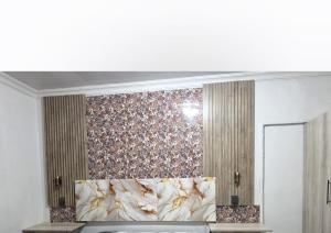 a room with a bed with a floral wall at MRH Self Check- In Express Homestay in Modimolle