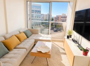 a living room with a couch and a large window at ideal in Carnon-Plage