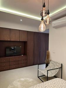 a living room with a chair and a tv and cabinets at Antilia home 1 in Abidjan +6 photos