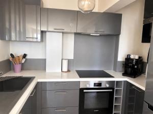 a kitchen with white cabinets and a black oven at ideal in Carnon-Plage
