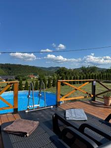 a wooden deck with a swimming pool and a table at Brvnara Beli in Gornji Milanovac +51 photos