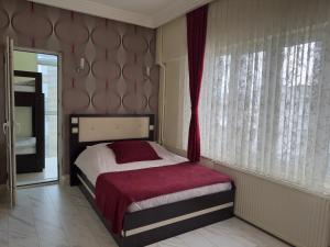 a bedroom with a bed and a large window at Otel Nisa in Nevşehir
