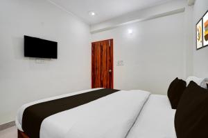 a bedroom with a bed with a television on the wall at Hotel O rudra paradise in New Delhi +21 photos