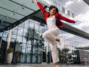 a woman jumping in the air in front of a building at Ibis Abu Dhabi Gate in Abu Dhabi