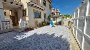 a courtyard of a house with a blue chair at Villa Guzi in Orihuela Costa