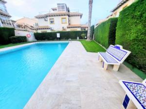 a blue bench sitting next to a swimming pool at Villa Guzi in Orihuela Costa