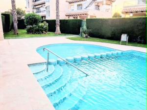 a swimming pool with blue water in a yard at Villa Guzi in Orihuela Costa +8 photos