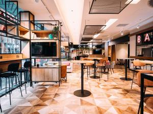 a restaurant with a bar and tables and chairs at ibis Belfast City Centre in Belfast