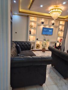 a living room with a couch and a television at Pearl Stay in Entebbe