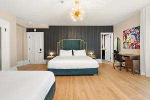 a hotel room with a bed and a desk at Manoir de la Tour - Par Aneyro in Quebec City