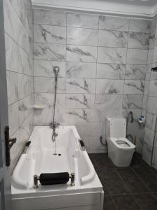 a bathroom with a bath tub and a toilet at Pearl Stay in Entebbe +9 photos