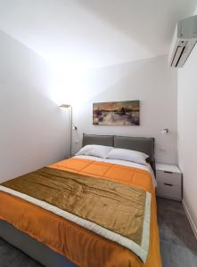 a bedroom with a bed with an orange bedspread at Blue sky in Milan