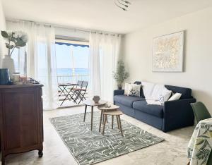 a living room with a blue couch and a table at Rives dor 1C in Juan-les-Pins