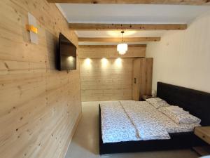 a bedroom with a bed and a tv on a wall at Apartments & Rooms Bojic in Kolašin