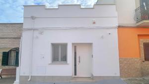 a white building with a door and a window at La Volta di Chiara in Roccaforzata