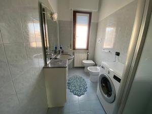 a bathroom with a sink and a washing machine at L'ora del tè in Cremona +1 photo