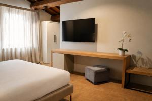 ein Schlafzimmer mit Bett und Flachbildfernseher in der Unterkunft La Quercetta in Foligno