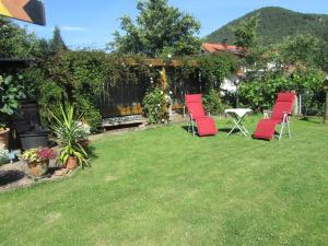 a group of red chairs and a table in a yard at Fewo Glaser in Lug