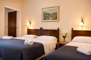two beds in a hotel room with towels on the beds at VillaGrancassa Hotel Relais in San Donato Val di Comino