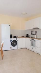 a kitchen with white cabinets and a washing machine at Sea View in Topola
