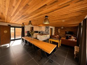 a kitchen and living room with a wooden ceiling at VinOli Holiday Home in Alveringem +24 photos