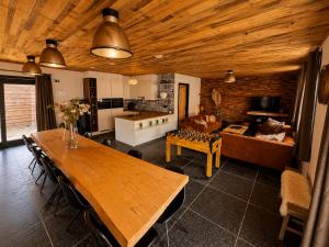 a kitchen and living room with a wooden ceiling at VinOli Holiday Home in Alveringem