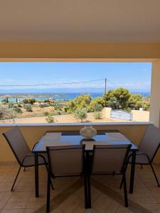 a table and chairs in a room with a large window at The Lookout by Goutos Luxury Living in Rozaíika +19 photos