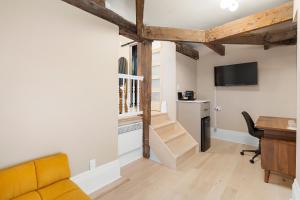 a living room with a desk and a table with a computer at Manoir de la Tour - Par Aneyro in Quebec City