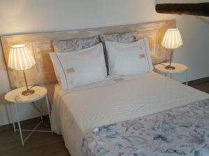 a bedroom with a bed with two lamps on tables at Islet House in São Roque