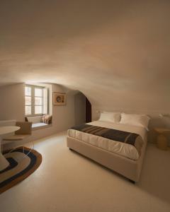 a bedroom with a bed and a desk and a window at Sant'Angelo Ostuni - Il Palazzo in Ostuni