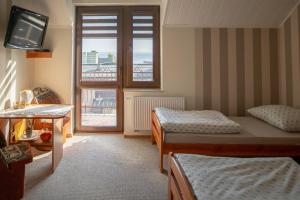 a room with two beds and a television and a balcony at Pokoje Iza in Chałupy +10 photos