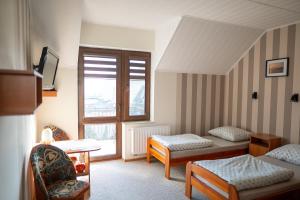 a hotel room with two beds and a window at Pokoje Iza in Chałupy