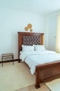 a bedroom with a large bed with a wooden headboard at Kivulini Homes in Arusha