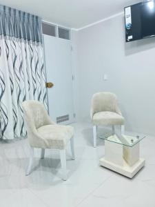 two chairs and a tv in a room at Montecarlo Hospedaje in Tacna