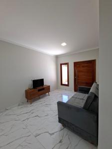 a living room with a couch and a television at Conforto e Tranquilidade, Casa Completa in Martins