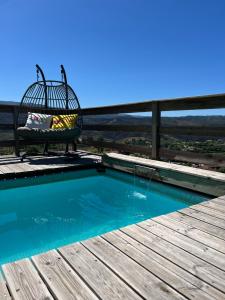 a chair sitting on a deck next to a swimming pool at Casinha in Celorico de Basto